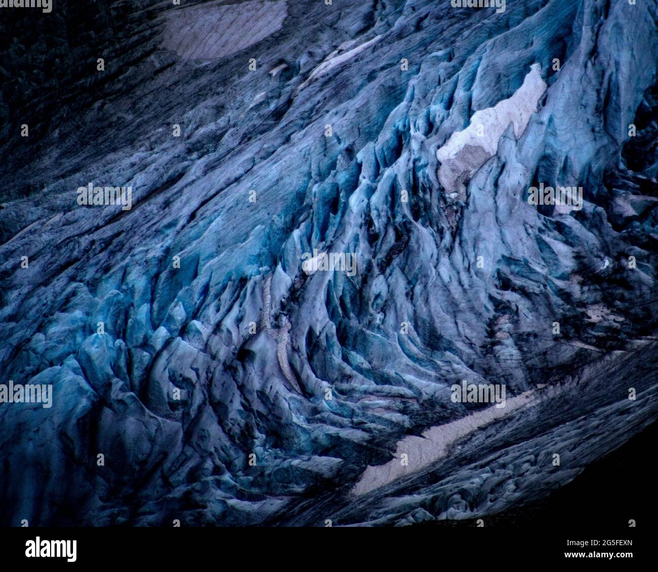 Des couches de neige blanche sont visibles sur l'ancienne glace bleue du glacier Stein à Gadmen en Suisse. Les glaciers des Alpes fondent rapidement en raison du réchauffement climatique et beaucoup d'entre eux devraient disparaître d'ici 2070. La couverture de neige blanche reflète la lumière du soleil et la chaleur beaucoup mieux que la glace plus sombre. L'hiver 2017/2018 a vu des quantités records de neige dans les alpes, mais les températures records en été ont fondu la plupart d'entre elles déjà en juin. Banque D'Images