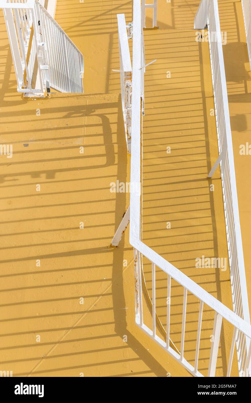 Ombres des rampes et des escaliers sur un sol jaune Banque D'Images