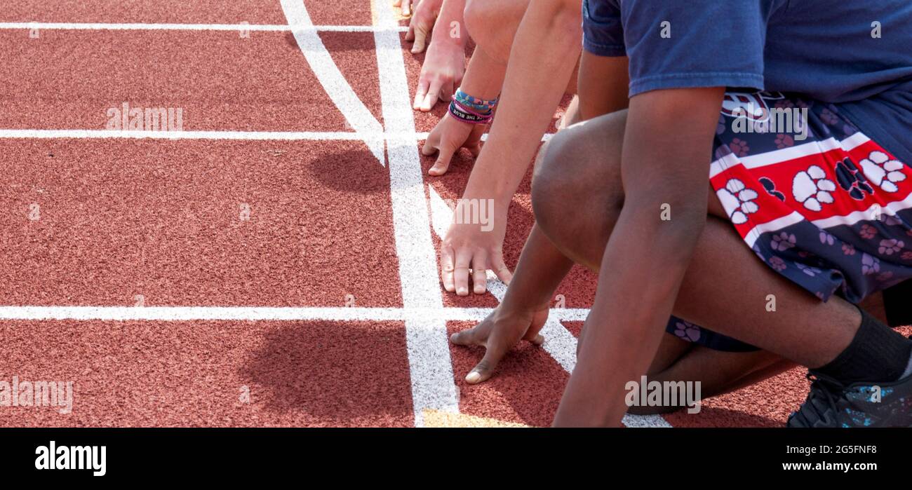 Vue latérale des mains et des bras des sprinters sur la ligne de départ, prêt pour la course sur piste Banque D'Images