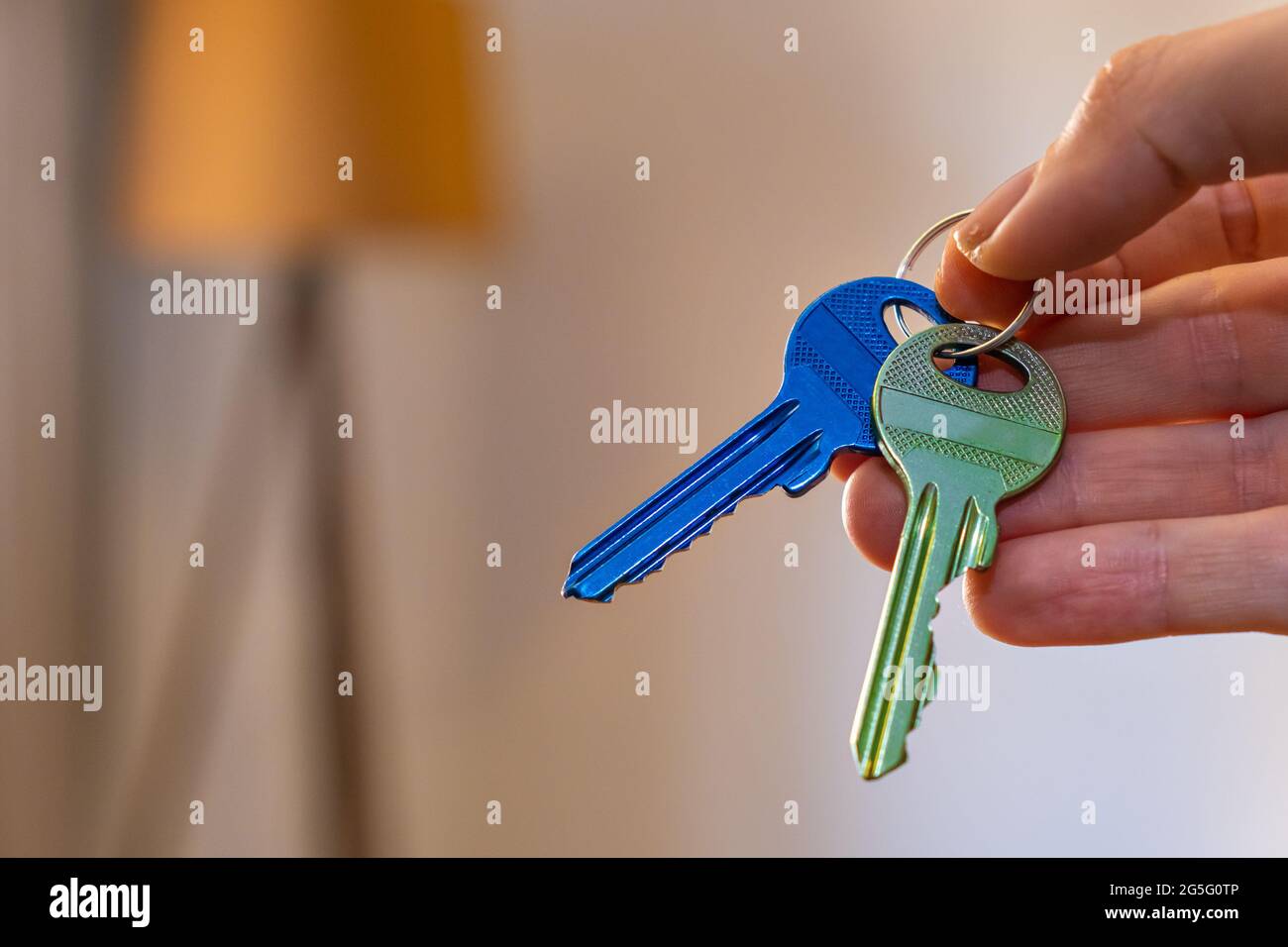 main tenant les clés avec la chambre sur fond. location vente achat appartement affaires immobilières Banque D'Images