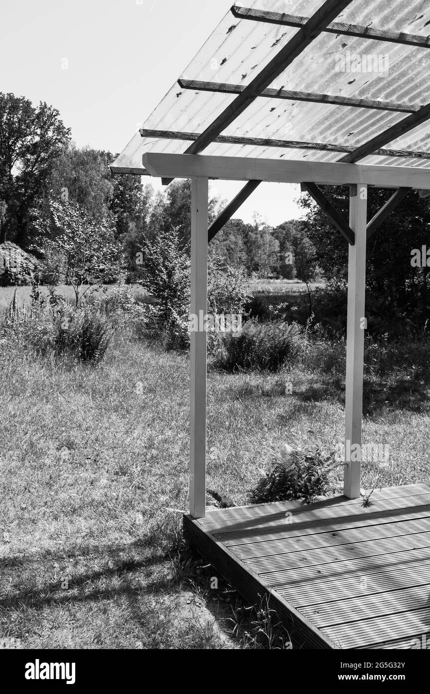 Terrasse couverte dans un jardin, avec une vue magnifique sur un grand pré Banque D'Images