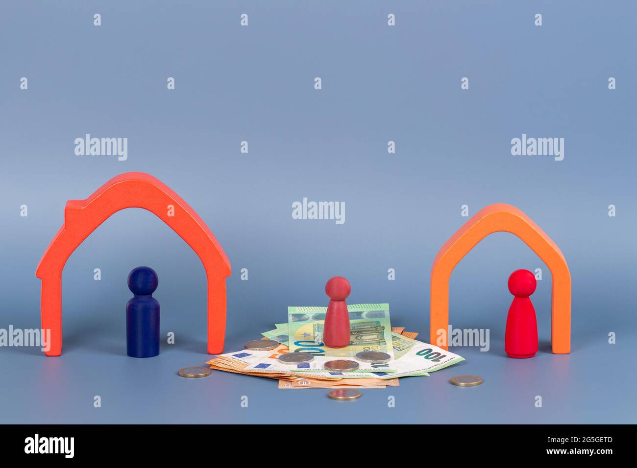 Divorce, conflit de parents, garde des enfants, partage des biens. Maisons en bois, figurines miniatures sur fond jaune Banque D'Images