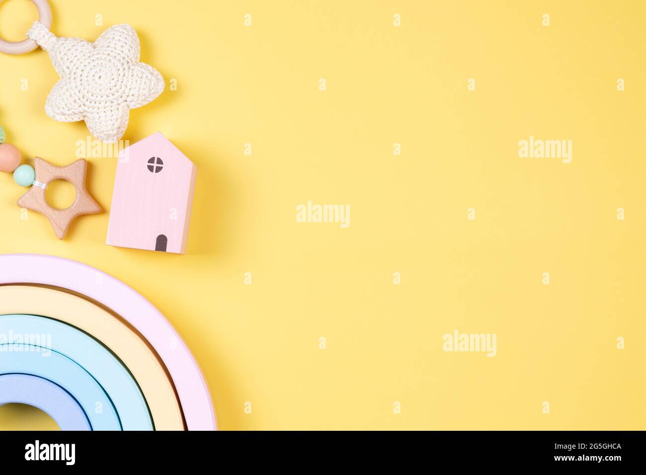 Jouets pour enfants sur fond jaune. Développement durable de la petite enfance produits pour bébés et jouets en bois de couleur pastel Banque D'Images