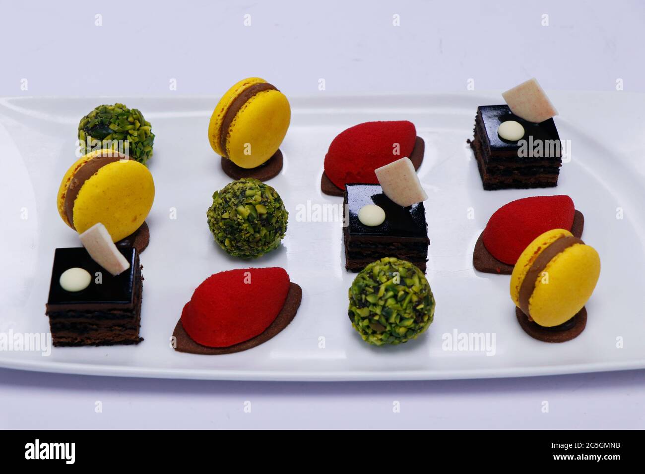 assortiment de pâtisseries françaises dans un plat comme petit four avec  macarons, gâteau au chocolat, boules de pistaches Photo Stock - Alamy