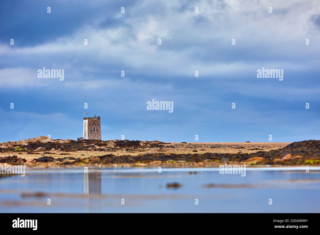 Image de la tour Seymour avec ciel nuageux et réflexion dans la piscine avec des ondulations. Jersey, îles Anglo-Normandes. Mise au point sélective Banque D'Images