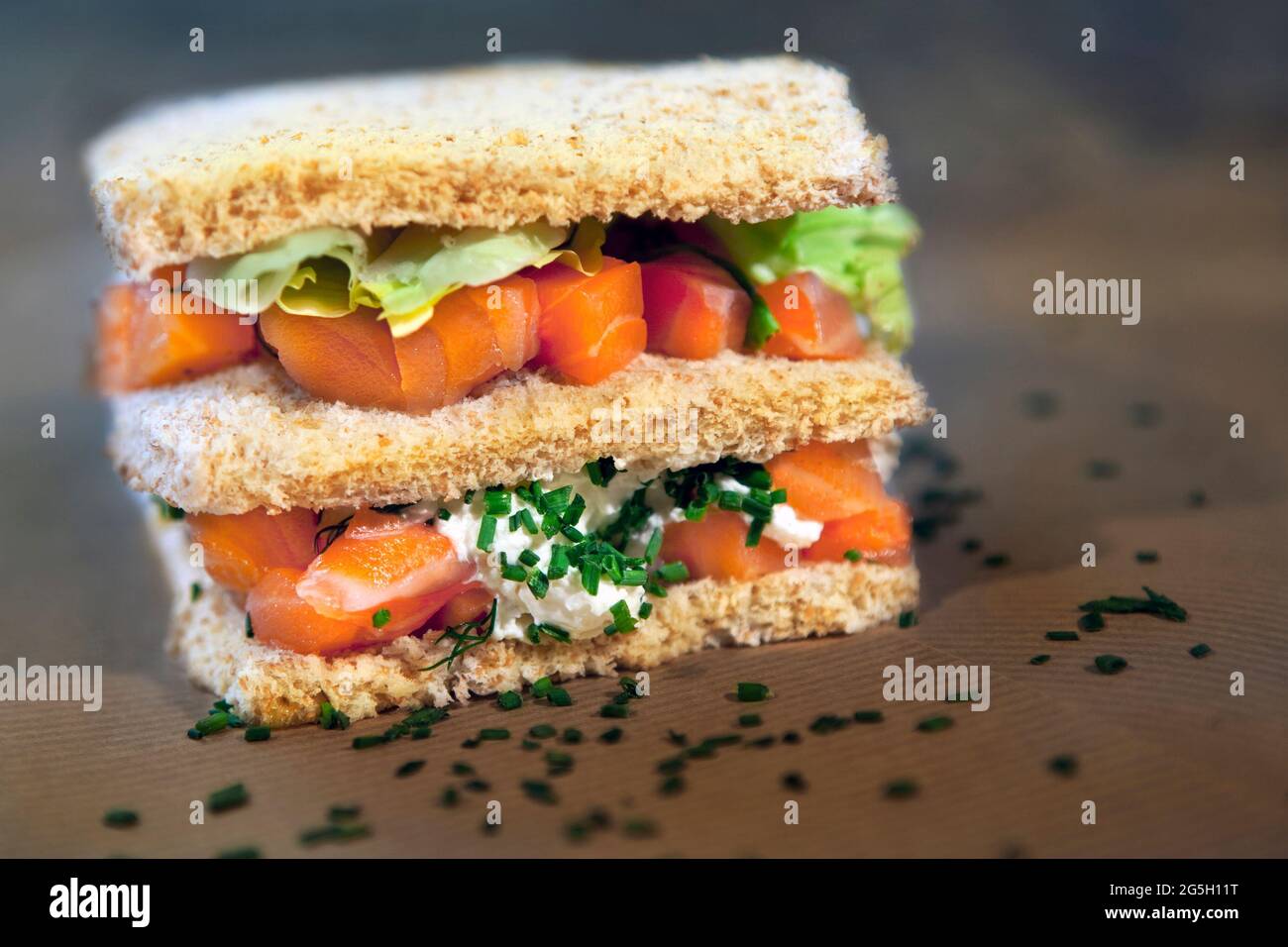 Saumon avec salade verte et crème à la ciboulette dans un pain sandwich Banque D'Images