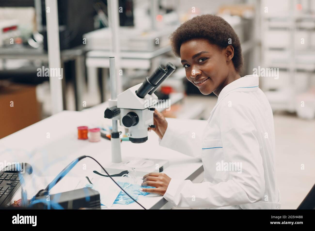 Femme de couleur dans la technologie. Scientifique afro-américaine femme travaillant en laboratoire avec des instruments de technologie électronique et un microscope. Banque D'Images