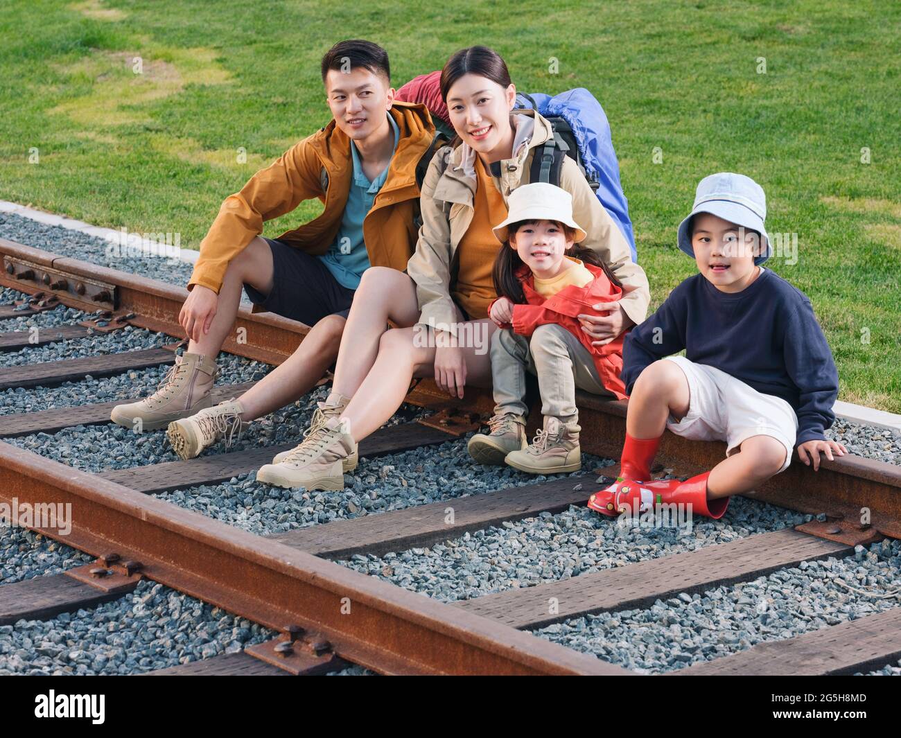 Une famille heureuse de quatre personnes assises sur la piste pour se reposer sur une photo de haute qualité Banque D'Images