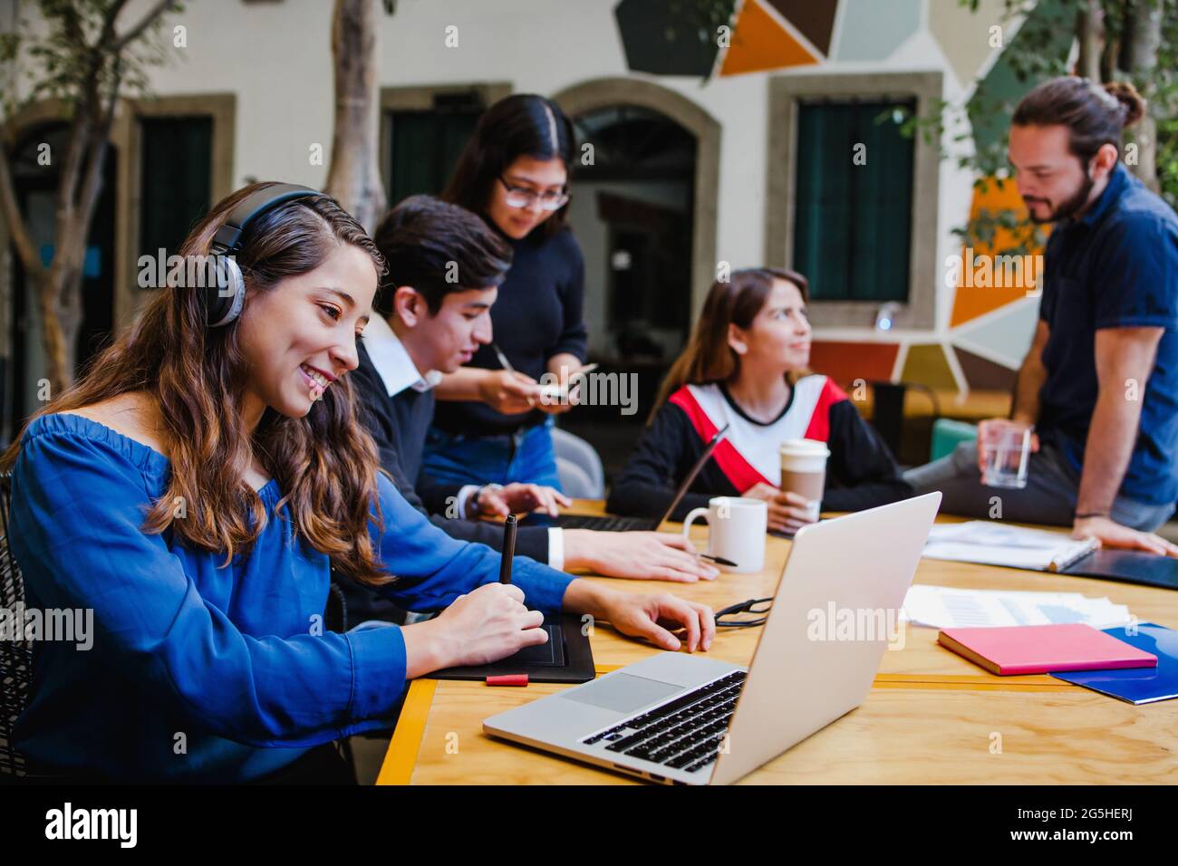 Jeune femme d'affaires latina avec casque sur la vidéoconférence sur le lieu de travail au Mexique Banque D'Images Jeune femme d'affaires latina avec casque sur la vidéoconférence sur le lieu de travail au Mexique Banque D'Images