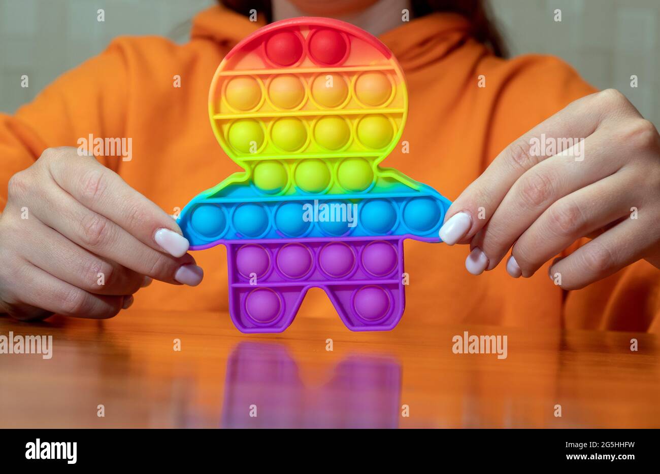 Dans les mains des femmes, un jouet pop-it sensible au toucher. Soulager le stress et l'anxiété. Un jeu tendance et difficile pour les enfants stressés comme pour les adultes. Sélectif Banque D'Images