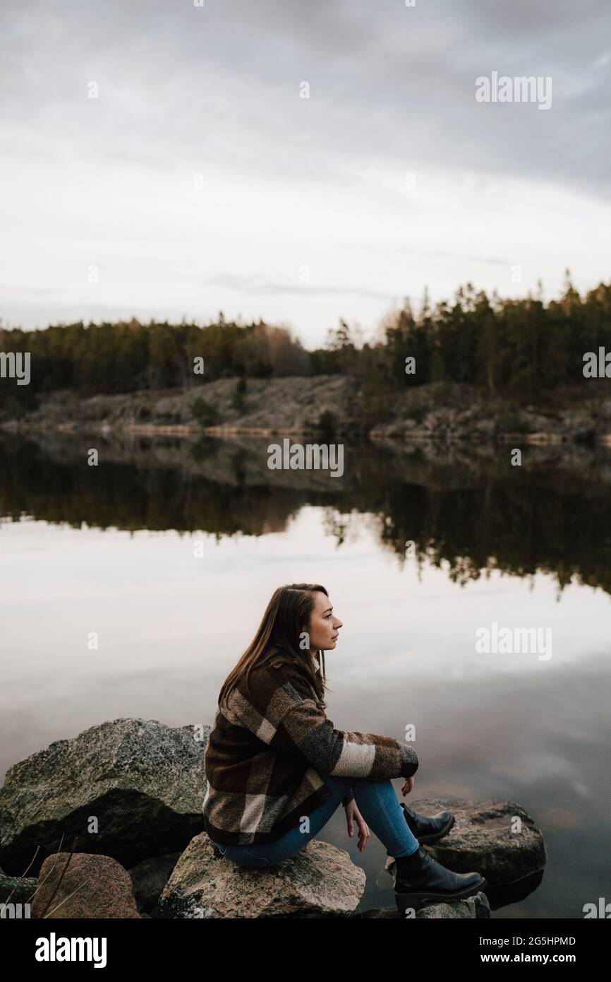 Femelle randonneur contemplant tout en explorant la forêt au bord du lac pendant les vacances Banque D'Images