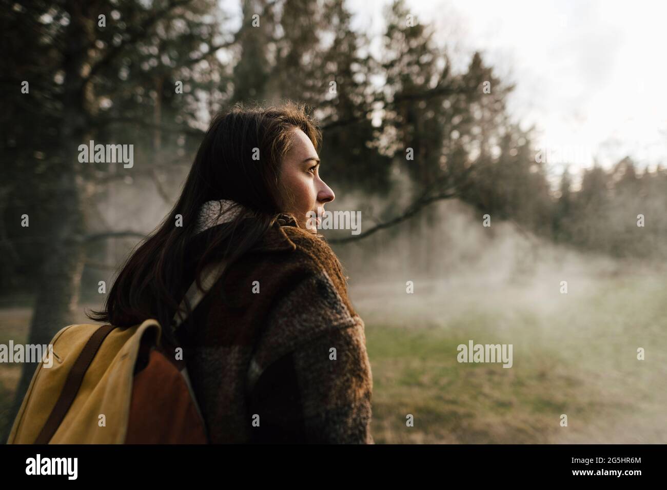 Femme randonneur explorant la forêt par temps brumeux Banque D'Images