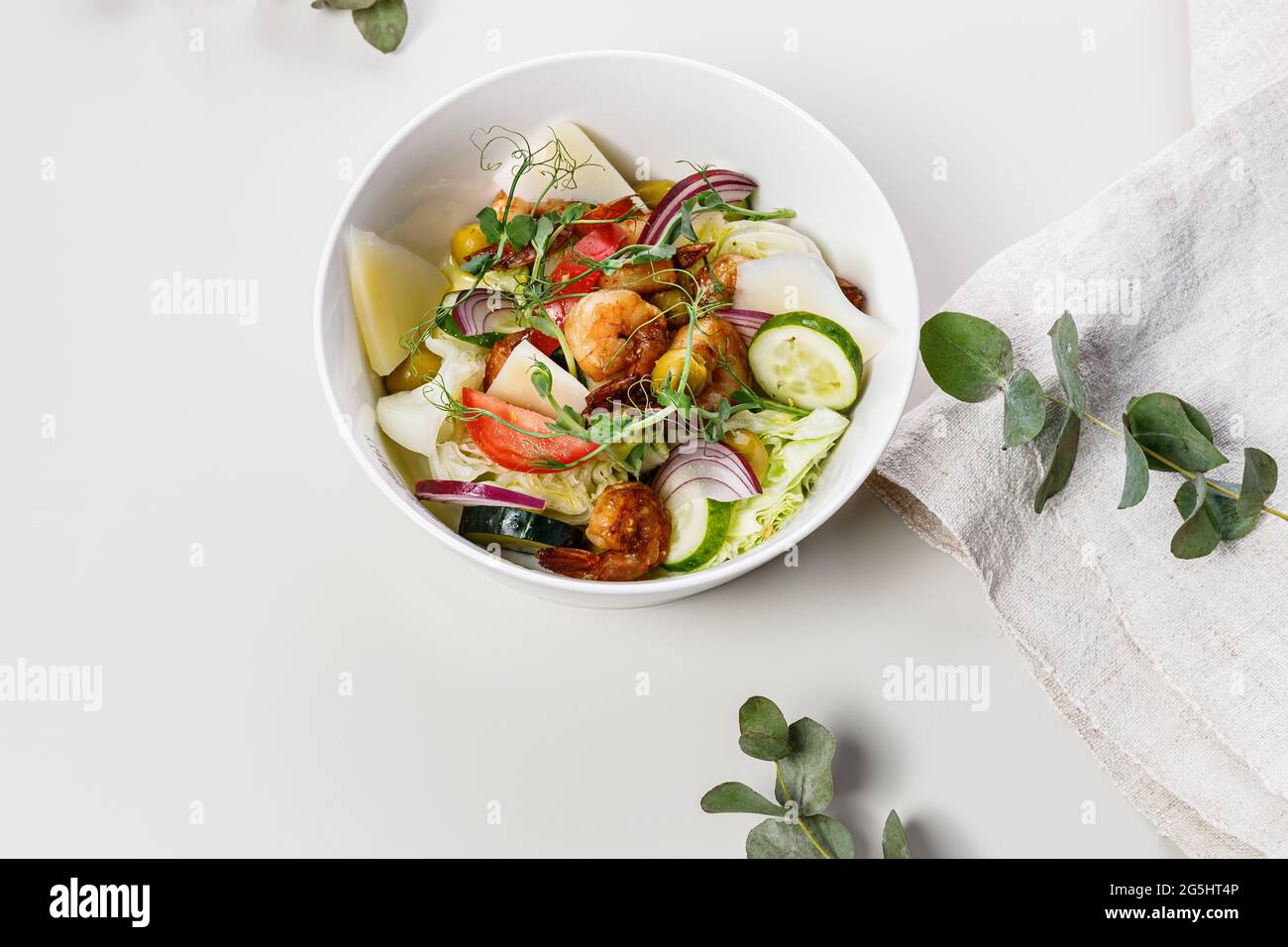 Salade d'été en gros plan avec légumes frais et fruits de mer sur fond blanc. Légumes de saison, crevettes et fromage de chèvre. Mediterr. Santé Banque D'Images