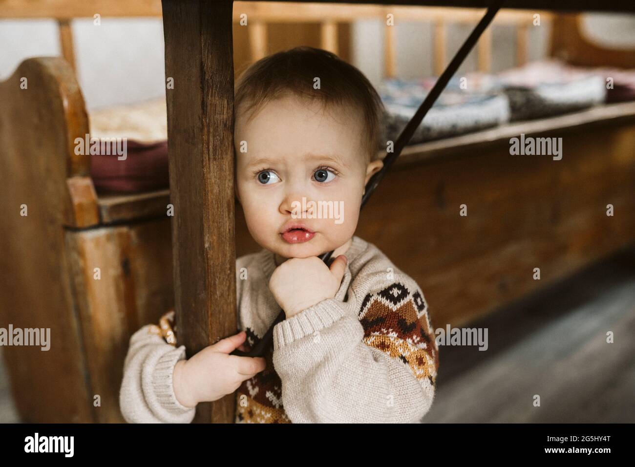 Fille avec les yeux gris debout sous la table à la maison Banque D'Images