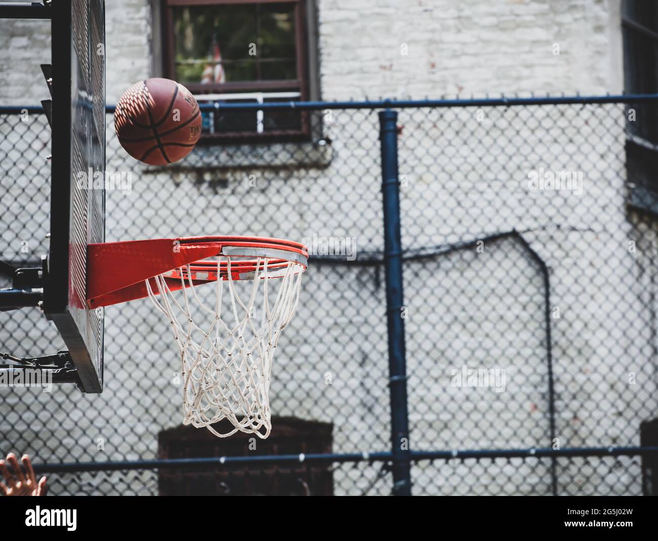 Panier de basket-ball dans un terrain de jeu de quartier à New Yor. La balle rebondit sur le bord prêts à entrer. Banque D'Images