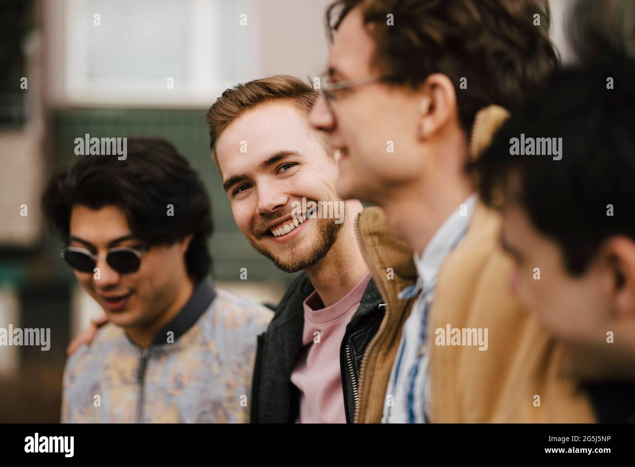 Joyeux jeune homme avec des amis masculins Banque D'Images