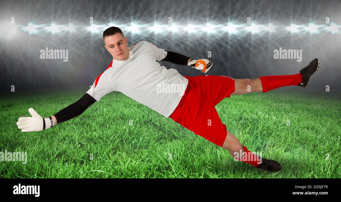 Composition du gardien de but masculin qui attrape le ballon au stade de football Banque D'Images