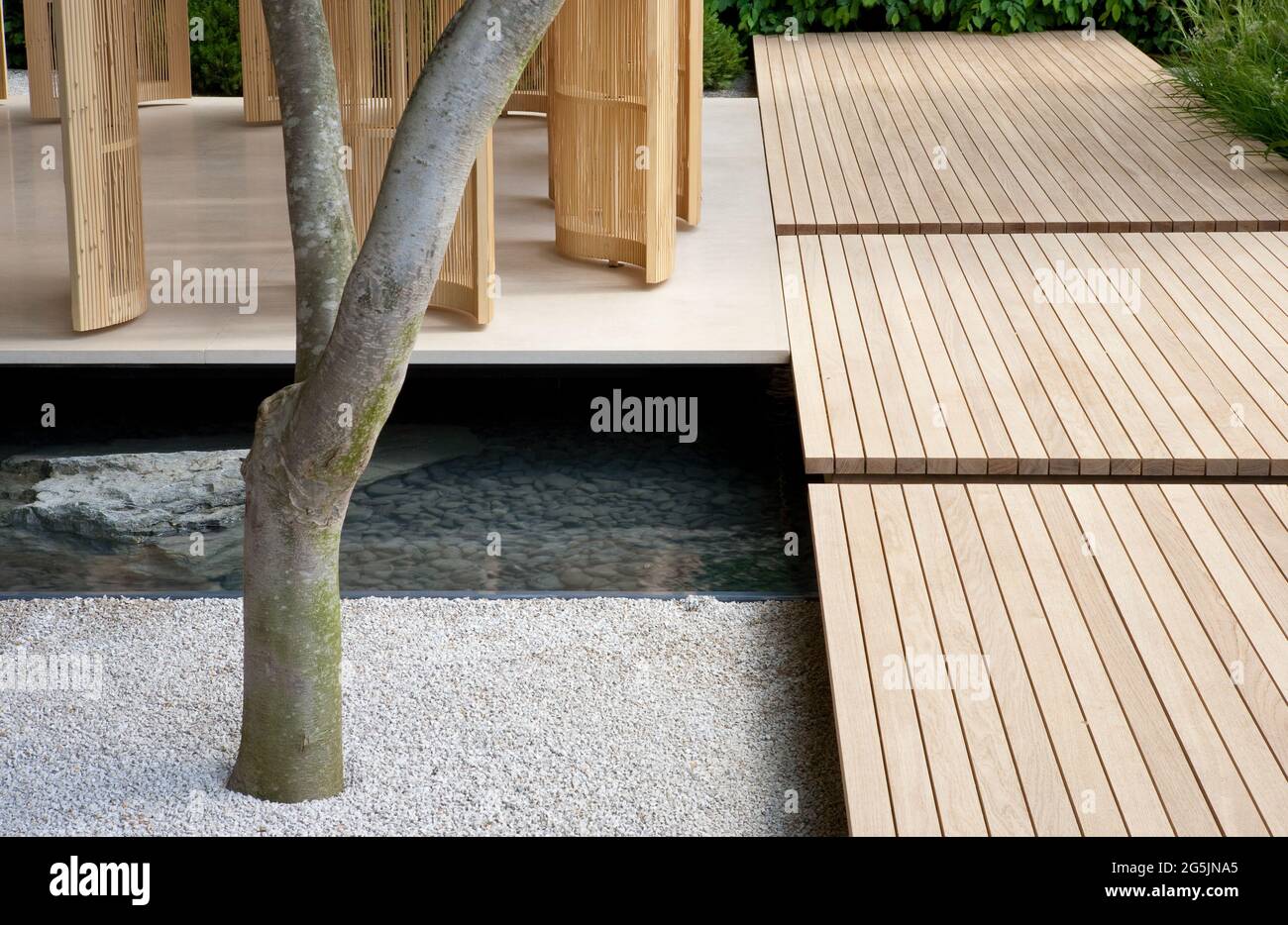 Jardin d'inspiration japonaise avec éléments d'eau en pierre, terrasse et pavillon en bois de bambou Banque D'Images