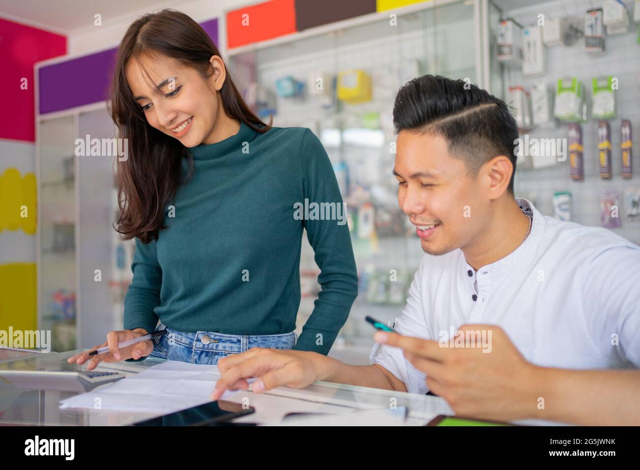 un couple travaille ensemble pour vérifier les enregistrements des accessoires de téléphone cellulaire Banque D'Images