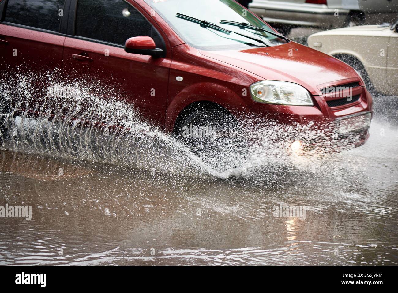 Projections de pluie sous les roues d'une voiture en cas de forte pluie. Banque D'Images