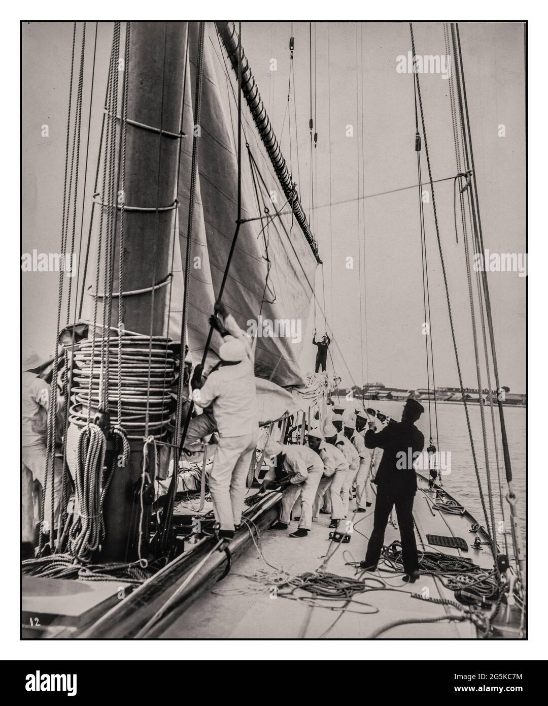 RELIANCE AMERICAS CUP 1900s Crew hissage mainsail sur le yacht Reliance, vainqueur de la coupe de l'Amérique 1903] l'image montre le couteau à gaffe conçu par Nathanael Greene Herreshoff et construit par Herreshoff Manufacturing Company, Bristol, Rhode Island, pour la coupe de l'Amérique 1903. Burton, James, photographe [1903 ]Reliance (Yacht)--1900-1910 - America's Cup--(12e :--1903 :--New York, N.Y.)--matériel et fournitures - Voiliers--American-1900-1910 Yachts--American--1900-1910 - voile--1900-1910 Banque D'Images
