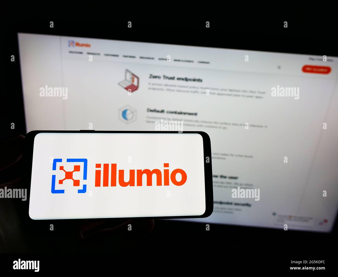 Personne tenant un téléphone portable avec le logo de l'entreprise américaine de sécurité de cloud computing Ilumio Inc. À l'écran devant la page Web. Mise au point sur l'affichage du téléphone. Banque D'Images