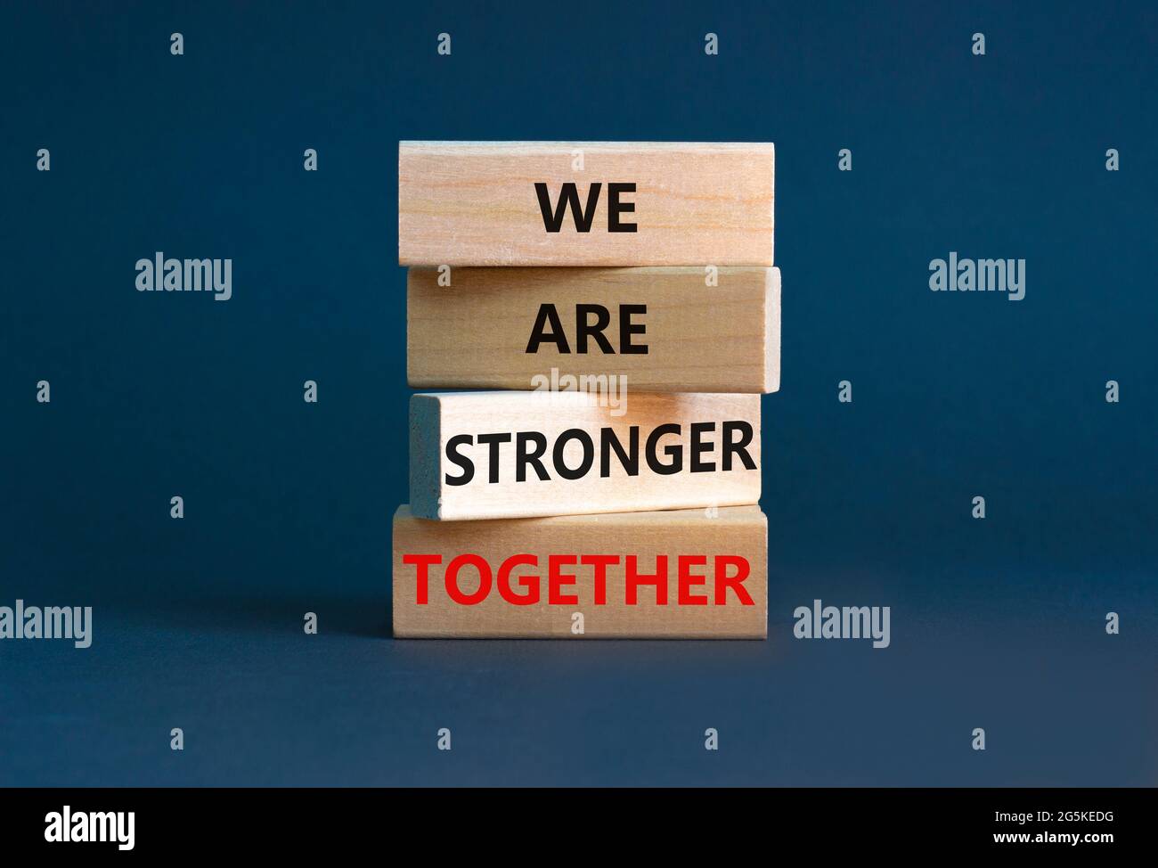 Symbole « plus fort ensemble ». Bloc en bois avec les mots « nous sommes plus forts ensemble ». Magnifique fond gris. Main d'homme d'affaires. Copier l'espace. Affaires, motif Banque D'Images