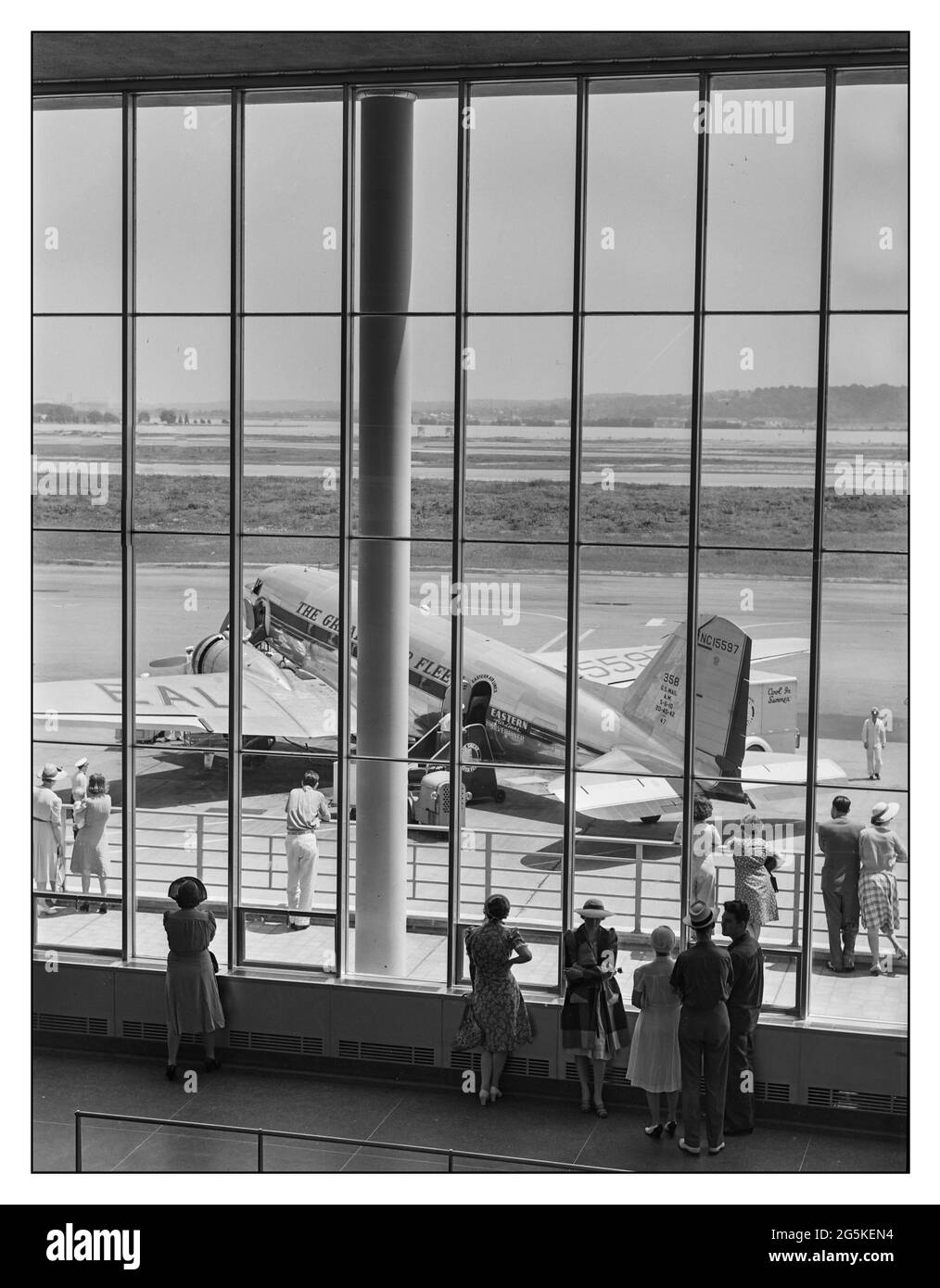 1940 American Airline Travel USA Eastern Airlines Silverliner DC3 Airliner sur le tarmac avec des visiteurs qui regardent l'activité, vu par la fenêtre de la salle d'attente. Aéroport municipal, Washington, DC par Jack Delano, photographe 1941 juillet. WW2 - États-Unis--District de Columbia--Washington (D.C.) Banque D'Images
