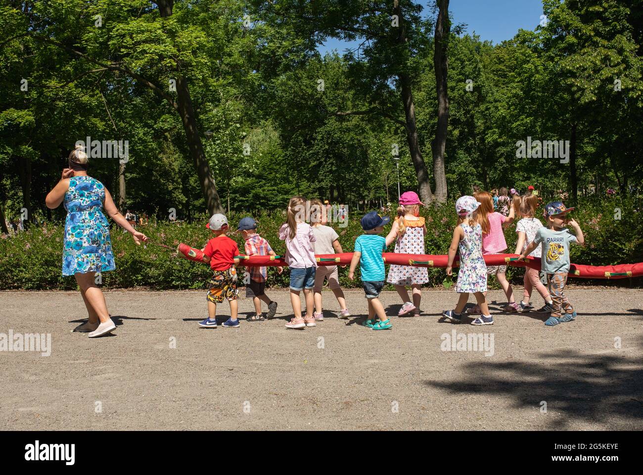 Gniezno, Pologne - UN groupe d'enfants d'âge préscolaire et leur gardien lors d'un voyage dans le parc. Enfants obéissants et organisés. Banque D'Images