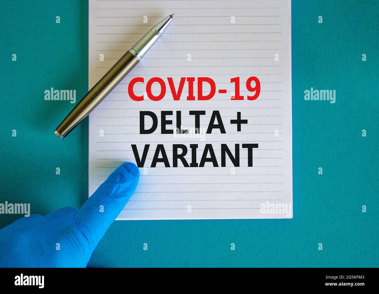 Symbole de déformation Covid-19 delta plus. Main dans un gant bleu avec carte blanche. Mots-clés Covid-19 delta plus variante. Stylo métallique. Médical, COVID- Banque D'Images