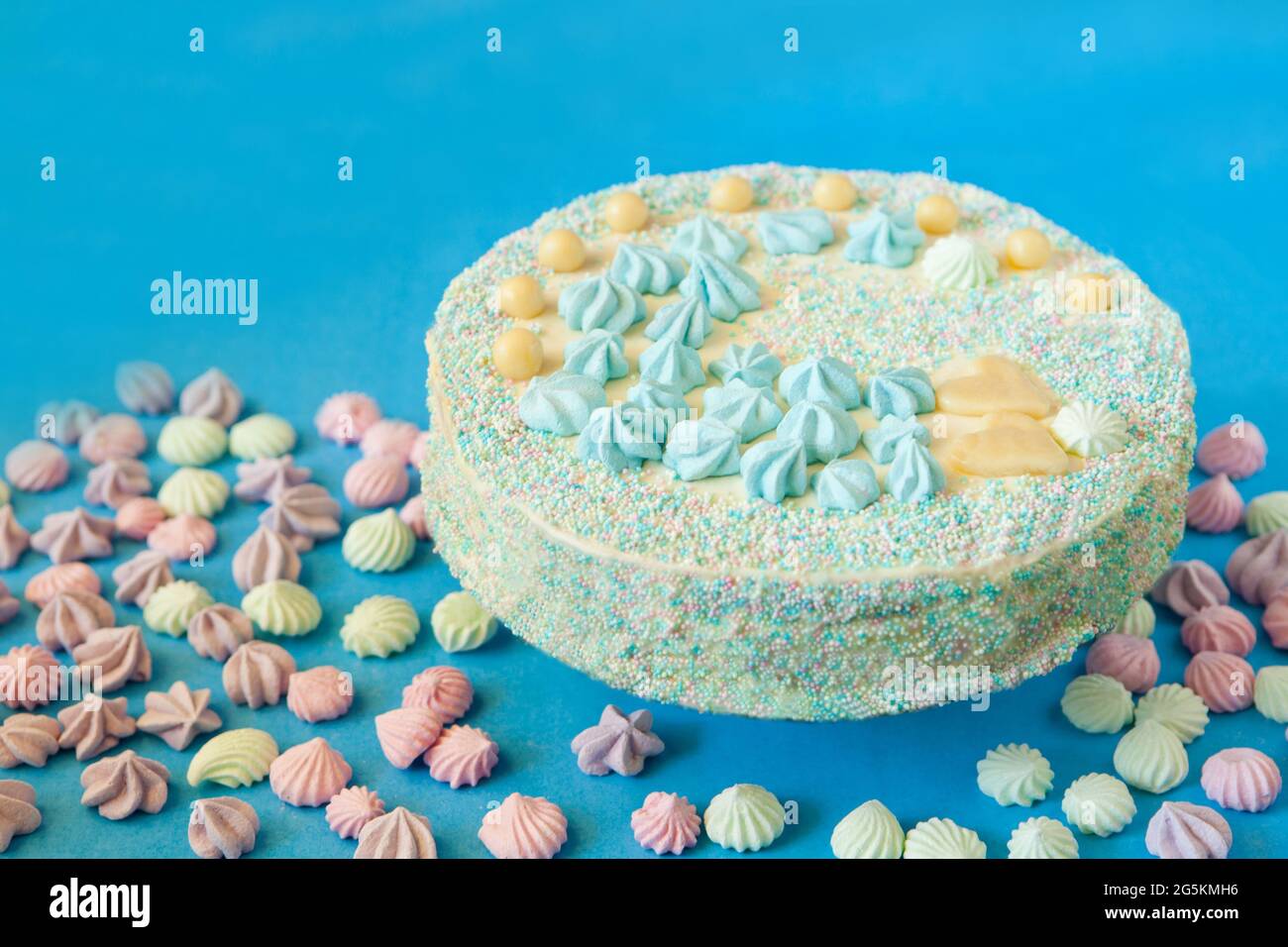 gâteau bleu avec bonbons pour la fête de la douche de bébé avec meringue. Gâteau fait maison pour un nouveau-né sur fond bleu. Banque D'Images
