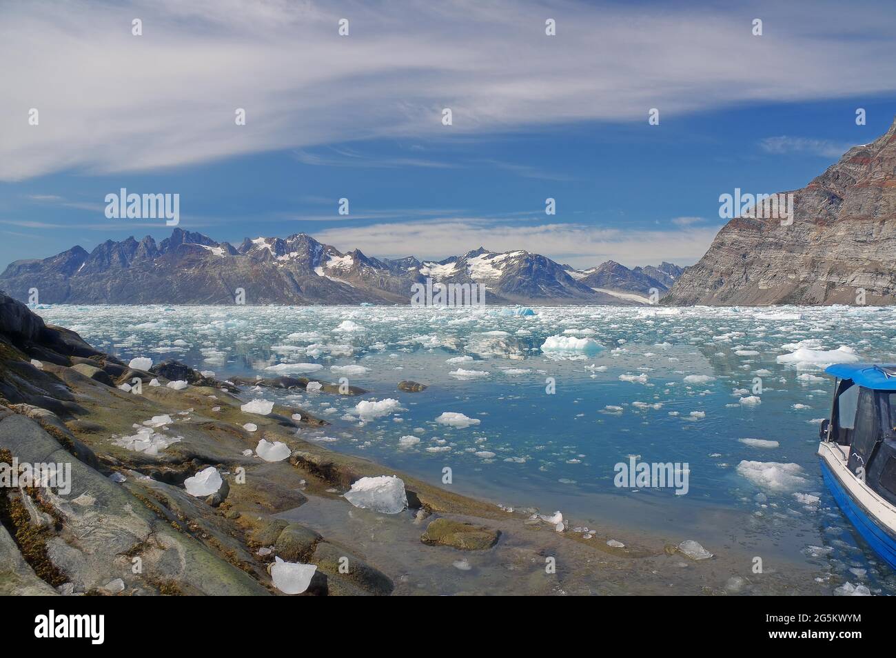 Vue sur la glace dérivante, bateau bleu, glace de glacier flottant dans le fjord, glacier Knud Rasmussen, Tasilaq, Groenland, Danemark, Amérique du Nord Banque D'Images