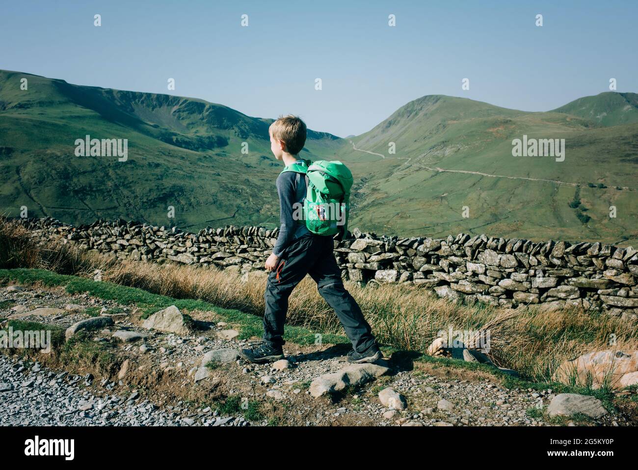 Garçon randonnée dans les montagnes dans le parc national de Snowdonia lors d'une belle journée Banque D'Images