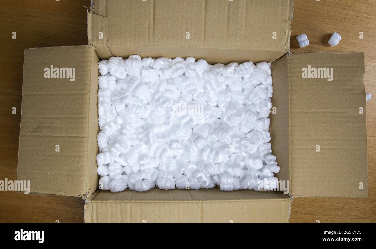 Une boîte en carton avec mousse d'emballage vue du dessus, boîte de livraison pour les produits fragiles sur une table en bois Banque D'Images