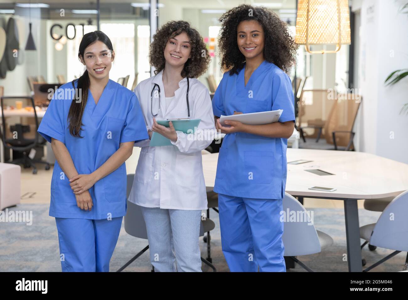 Jeune femme équipe de travail médical portant l'uniforme de travail souriant et regardant la caméra. Banque D'Images