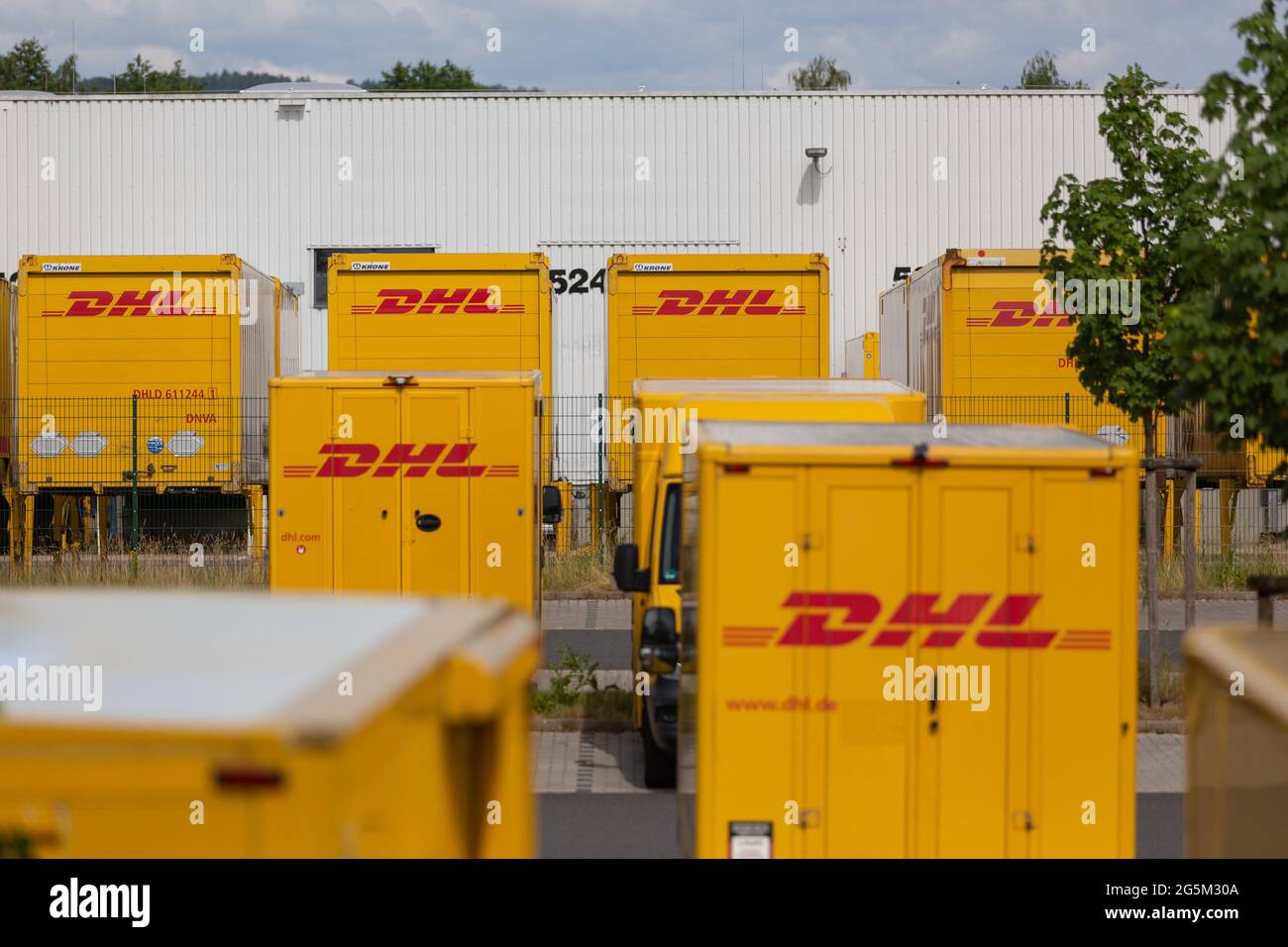NEUWIED, ALLEMAGNE - 18 juin 2021 : Neuwied, Allemagne - 20 juin 2021 : conteneurs et camionnettes DHL devant un dépôt DHL Banque D'Images