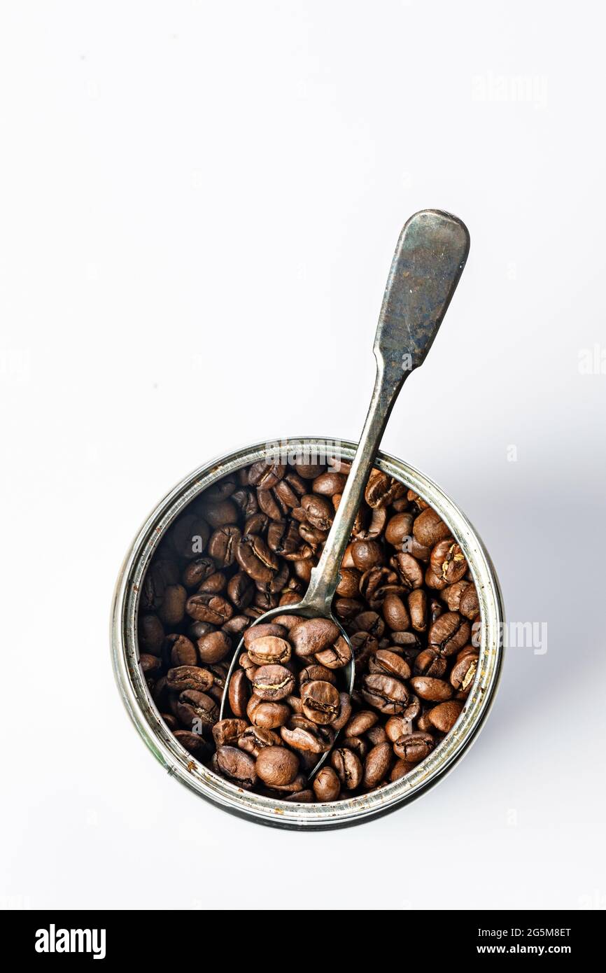 Boîte contenant des grains de café. Un bocal ouvert avec de l'arabica aromatique rôti sur fond blanc traditionnel boisson du matin. Copier l'espace. Thème de l'heure du café. T Banque D'Images