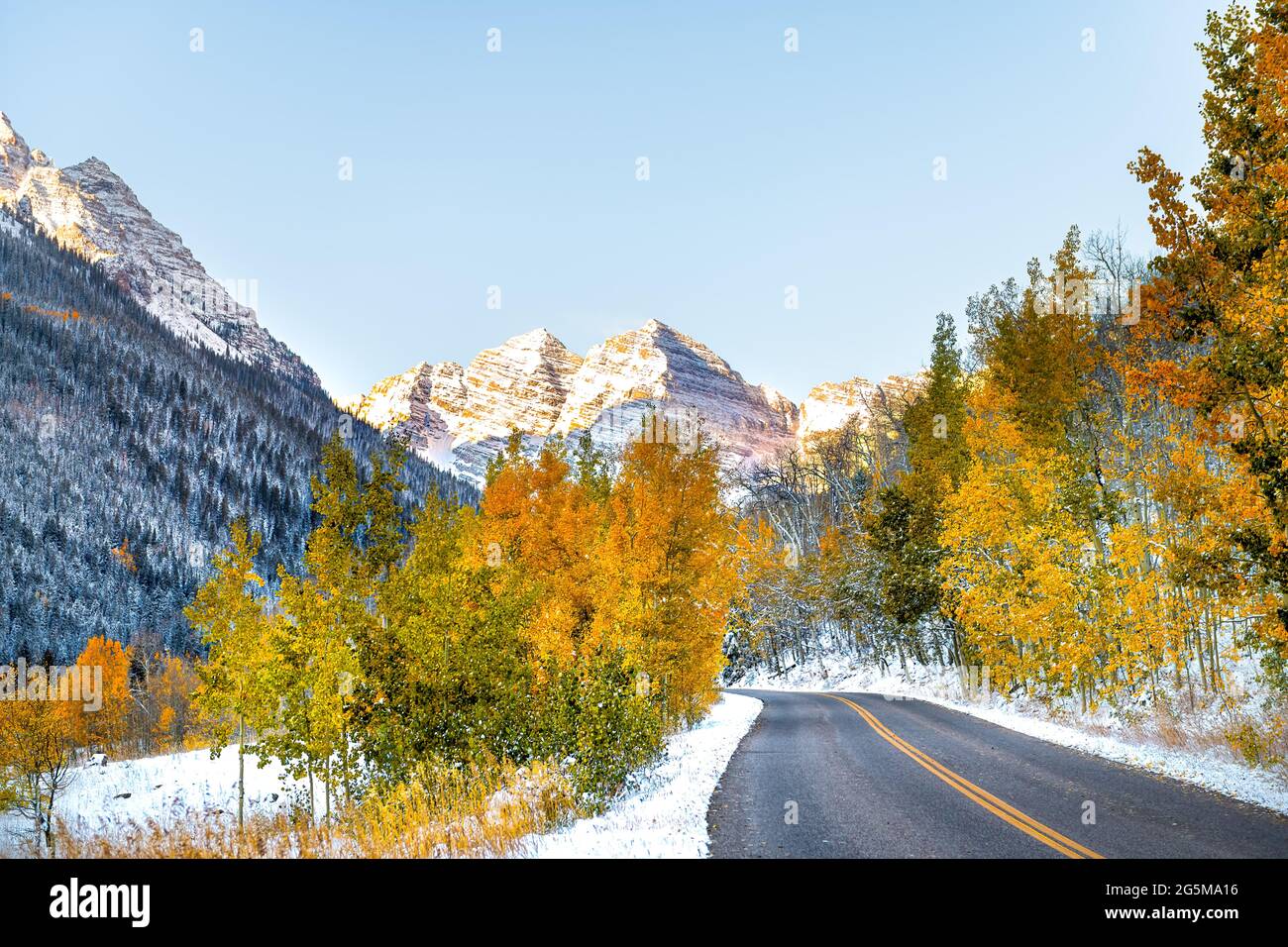 Les Maroon Bells atteignent le sommet du lever du soleil à Aspen, Colorado, montagne rocheuse et vue sur le feuillage jaune d'automne et hiver neige des arbres gelés sur la route du ruisseau Banque D'Images