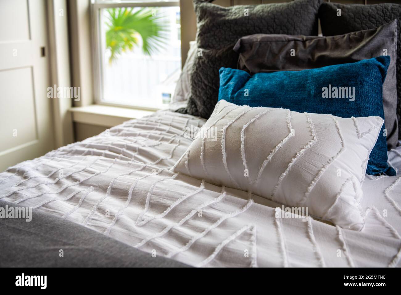 Gros plan d'un nouvel édredon de lit avec coussins décoratifs blancs bleus  dans la chambre à coucher dans la maison de repos, maison ou appartement de  style moderne Photo Stock - Alamy