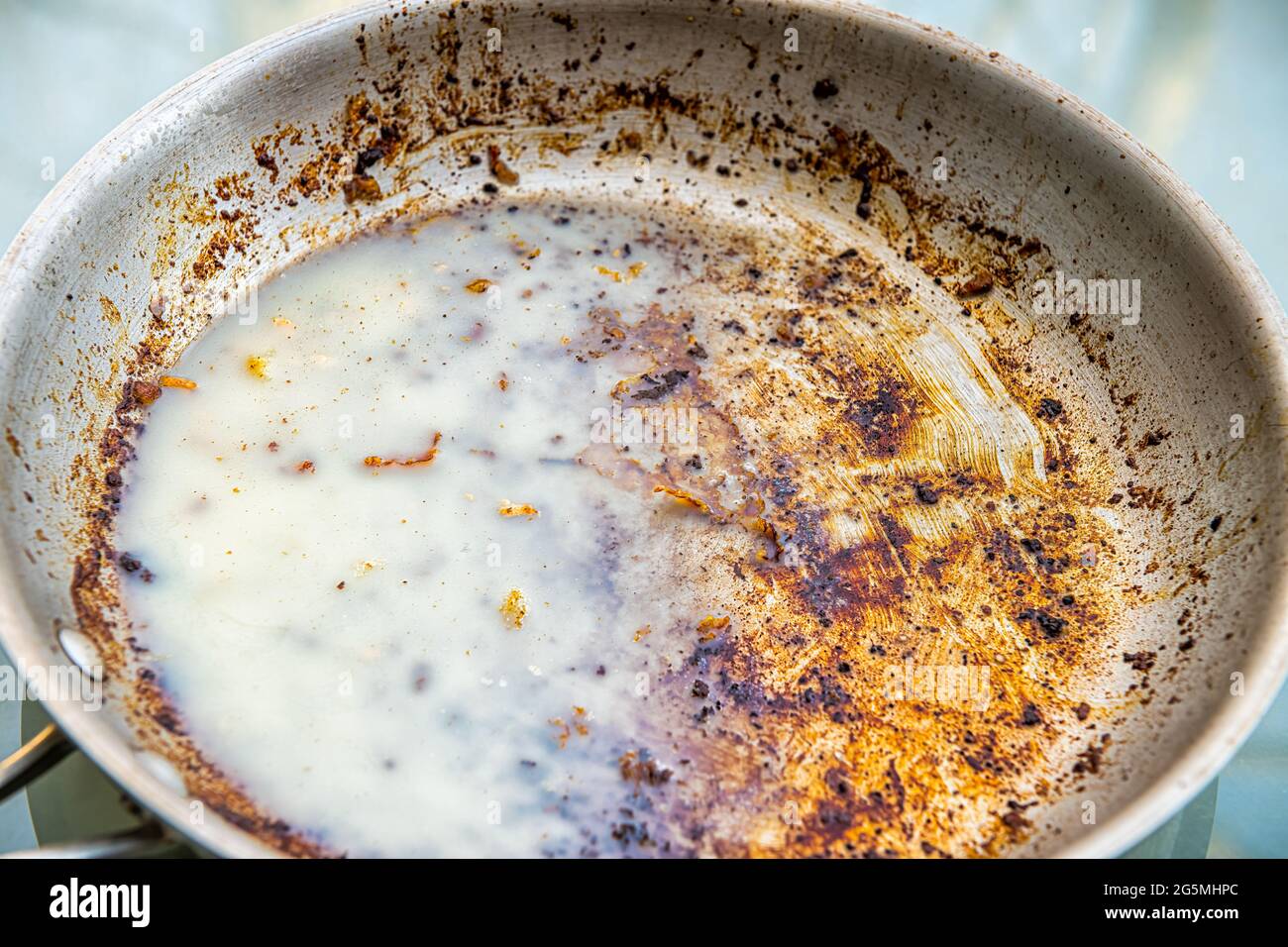 Une casserole huileuse sale avec de la graisse froide saturée de graisse du bacon après la friture macro gros plan comme travail de nettoyage des restes malsains Banque D'Images