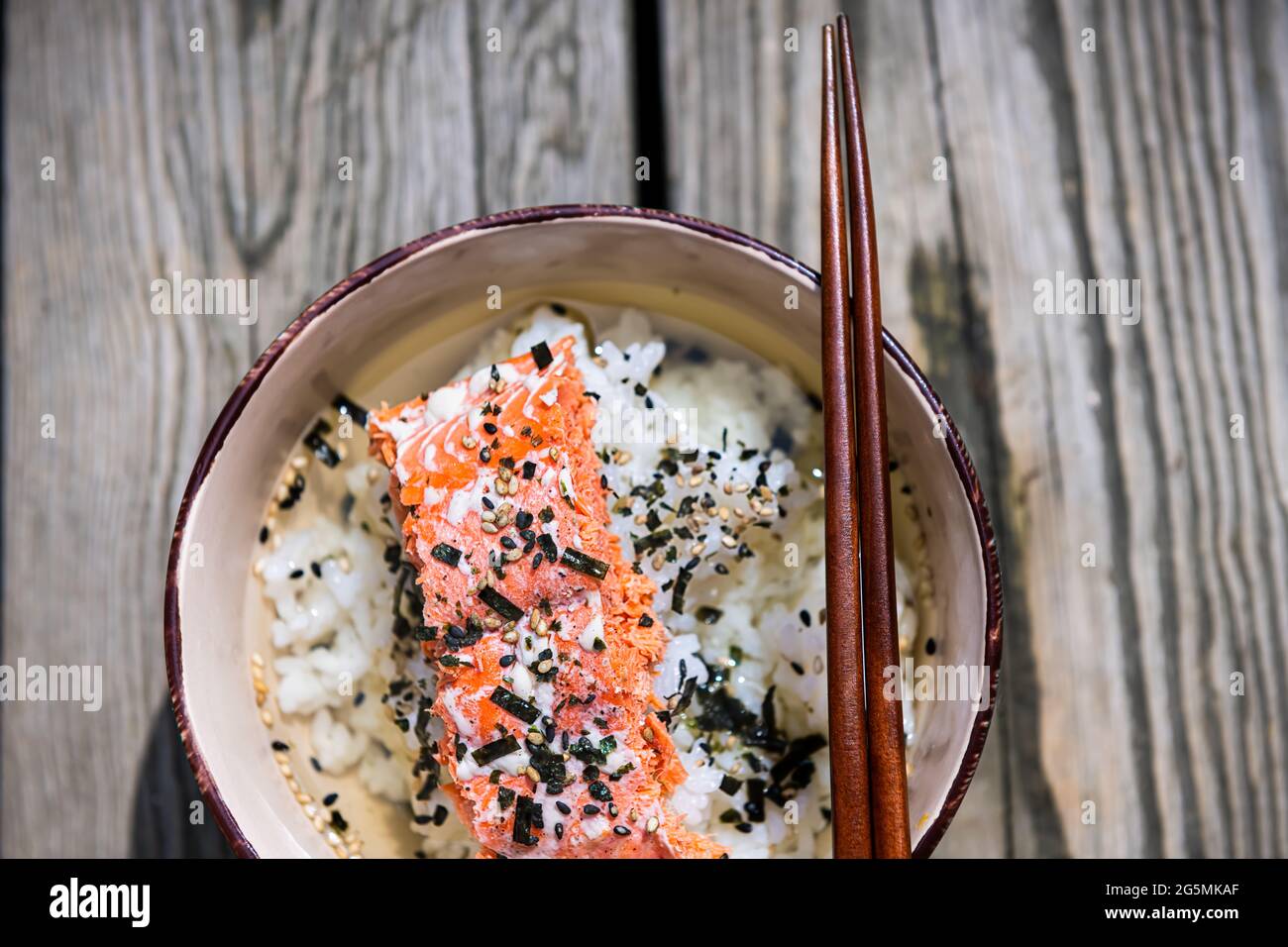 Gros plan du plat traditionnel de thé vert japonais en Asie appelé ochazuke avec saumon grillé, furikake de graines de sésame de riz et nori dans un bol avec côtelettes Banque D'Images