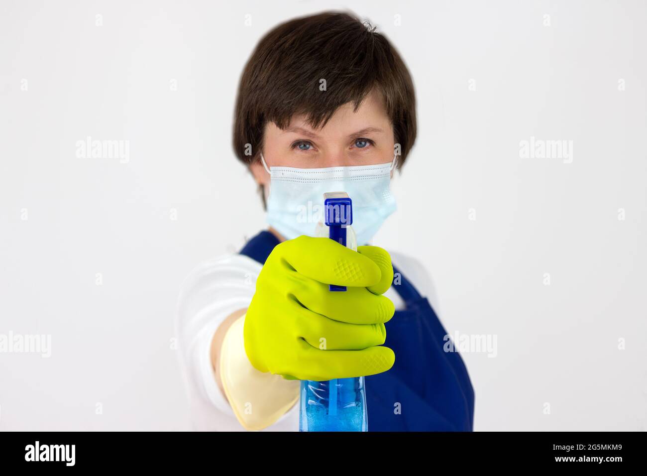 Le concept de désinfection et de nettoyage intérieur.nettoyage lady vaporise de spray. Femme en uniforme et gants en caoutchouc tenant le spray nettoyant avec propre Banque D'Images