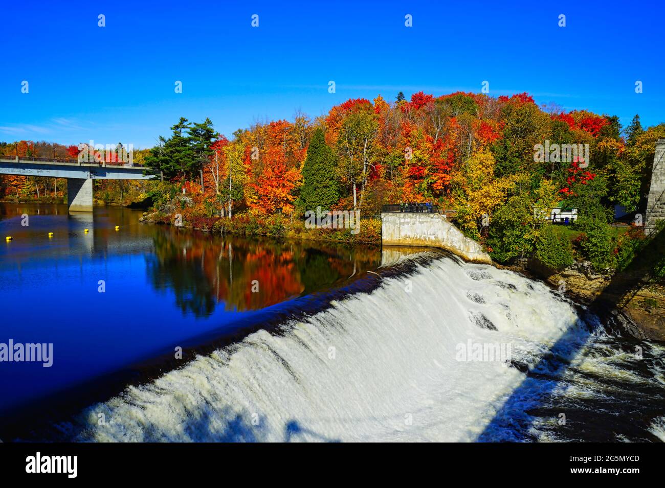 Les chutes et le pont en automne avec des arbres colorés et le ciel bleu. Parc des chutes Montmorency (Parc de la chute-Montmorency), Québec, Canada, 2016. Banque D'Images