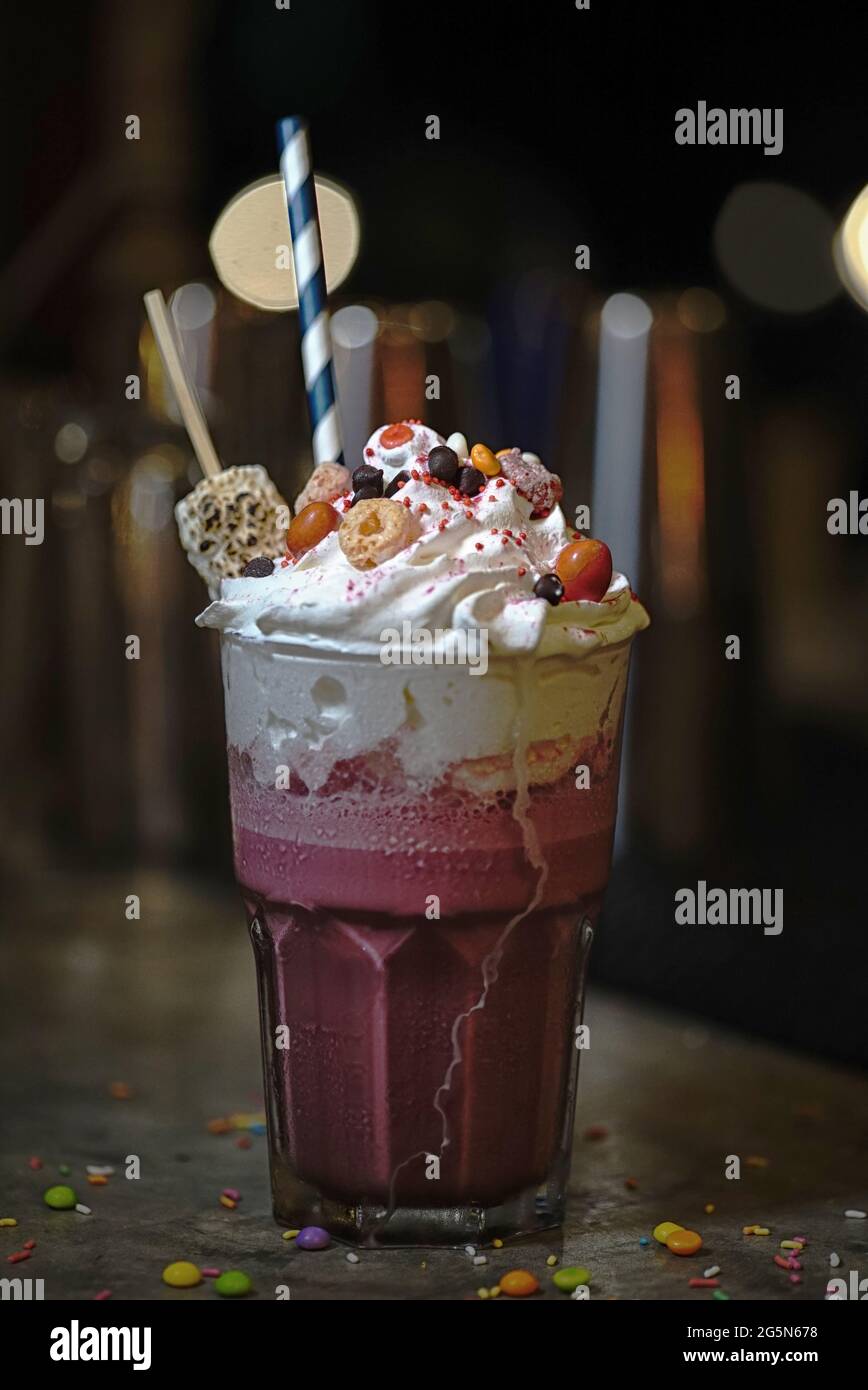 milk-shakes aux fraises avec bonbons, gaufres, pop-corn, guimauve, crème glacée et crème fouettée Banque D'Images