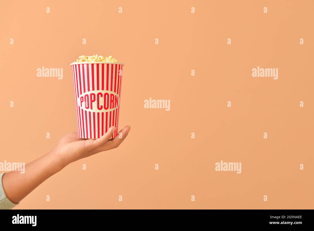 Seau à main pour homme avec pop-corn sur fond de couleur Banque D'Images