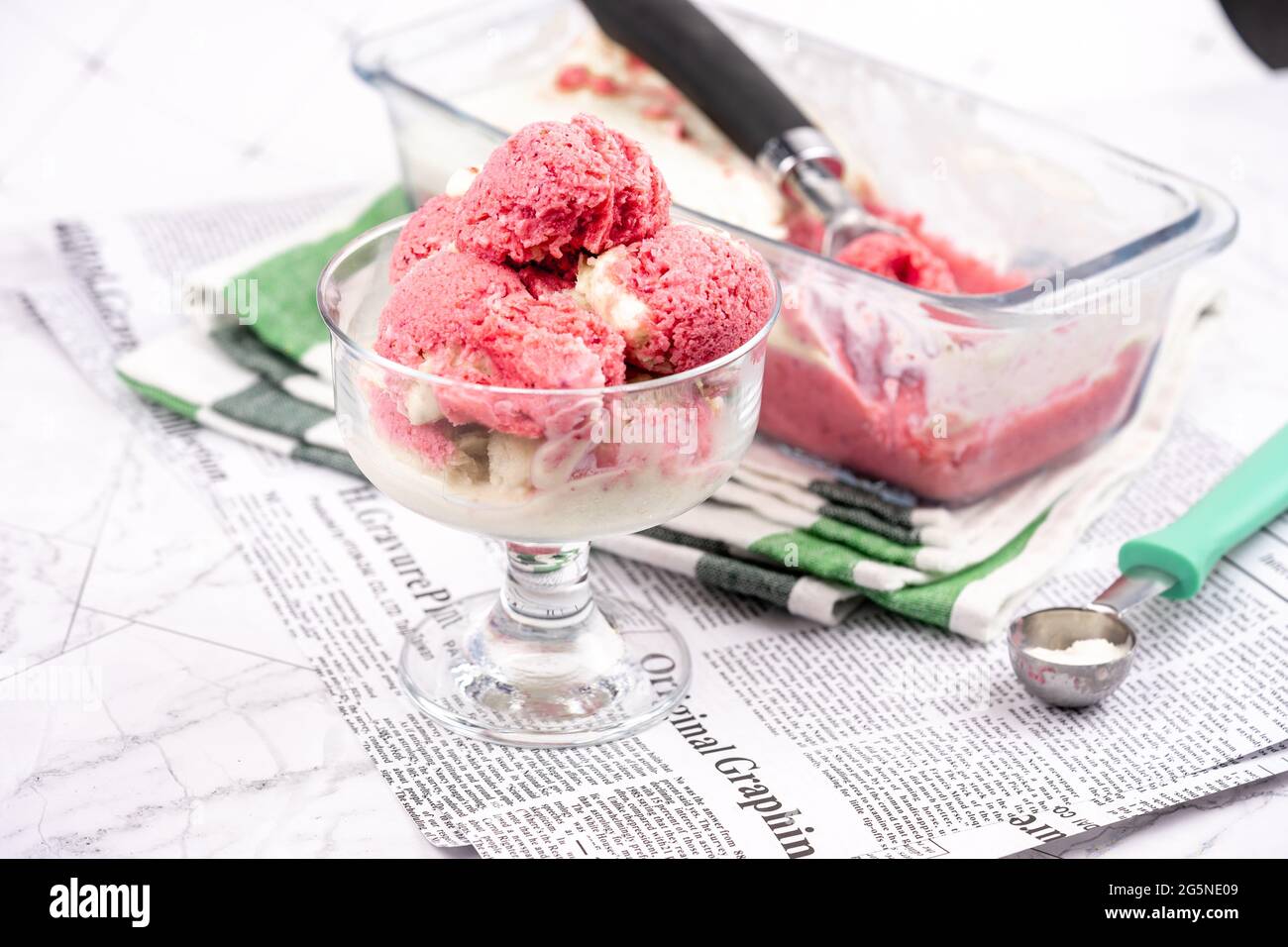 Yaourt glacé à la fraise dans un bol en verre, boules de crème glacée, contenant avec sundae faits maison Banque D'Images