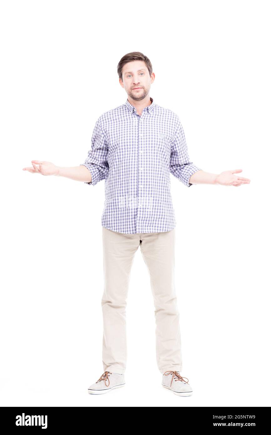 Portrait vertical sur toute la longueur d'un homme caucasien confus portant une chemise à carreaux bleus doutant quelque chose, fond blanc Banque D'Images