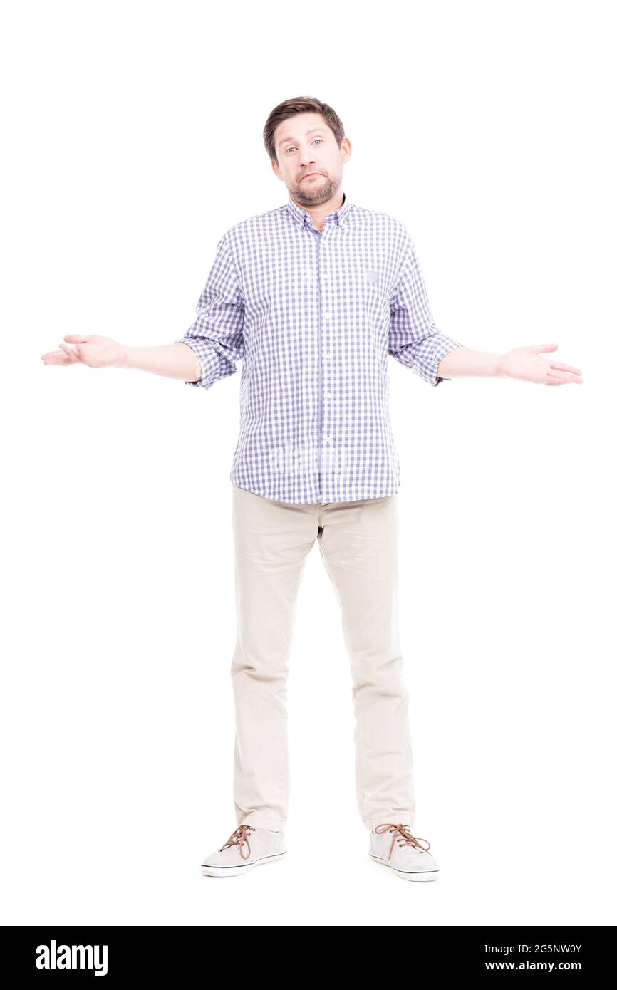 Portrait vertical sur toute la longueur d'un homme caucasien confus portant une chemise à carreaux bleus doutant quelque chose, fond blanc Banque D'Images