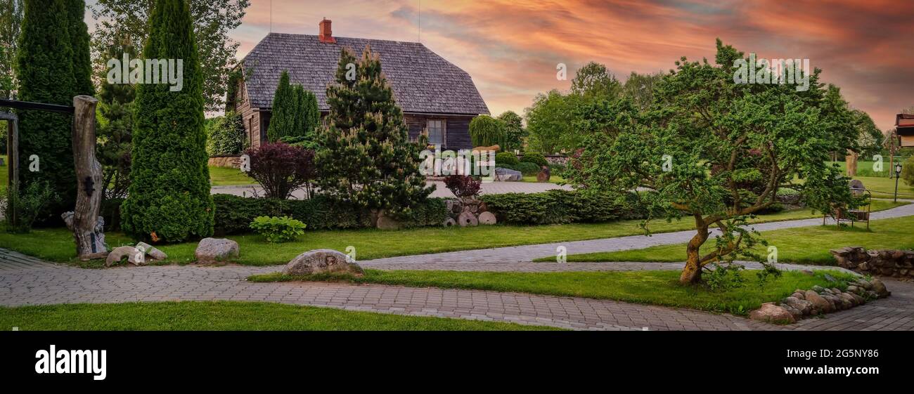 beau jardin paysagé en face de la vieille maison en bois. espace de copie de bannière Banque D'Images