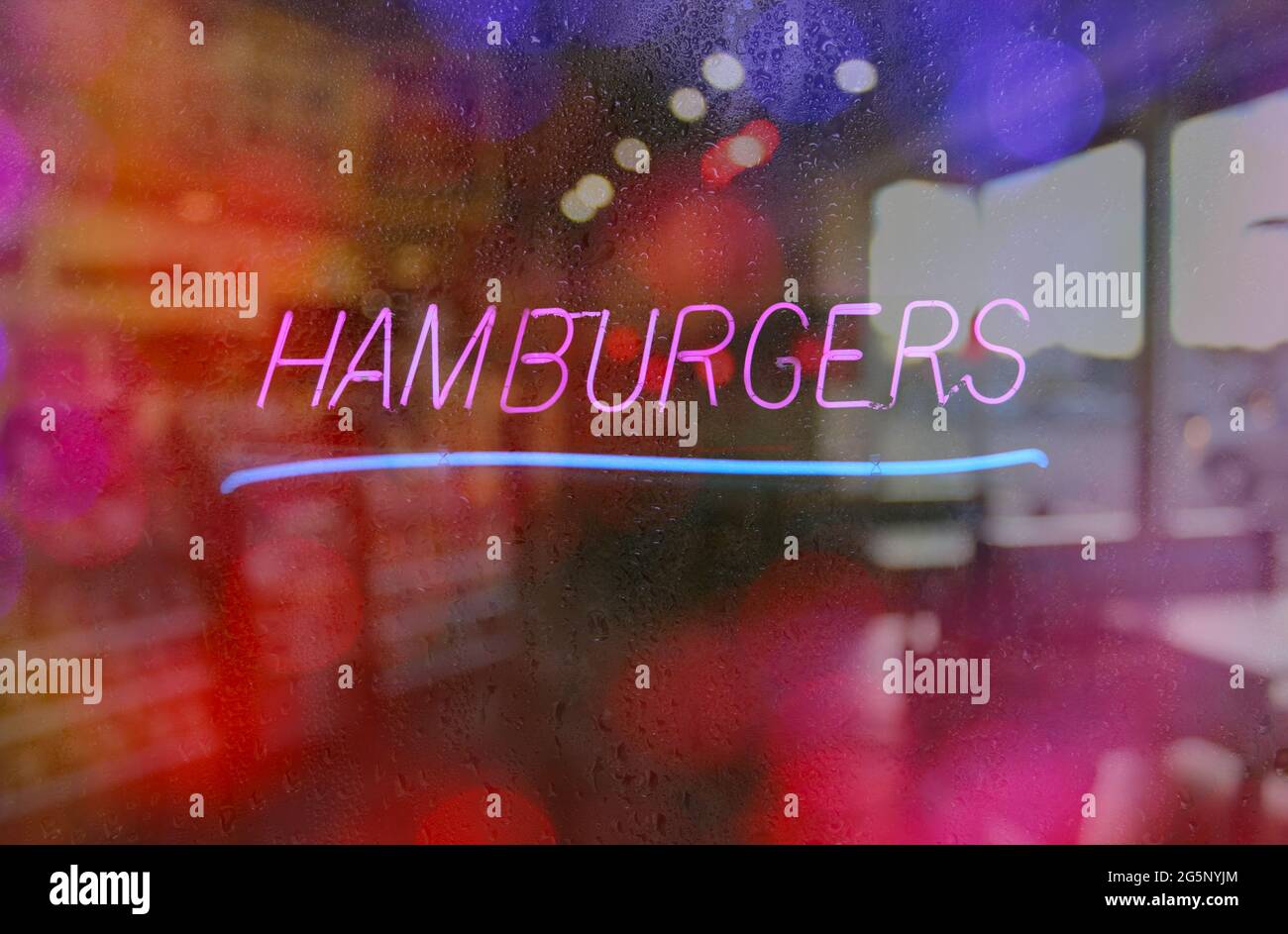 Image floue Neon Rainy Window, Retro Diner avec enseigne Hamburger Banque D'Images